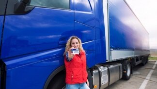 Truck driver showing commercial driving license. CDL training.